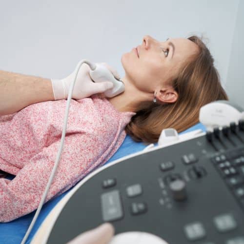 A woman having a neck ultrasound at her endocrinologist