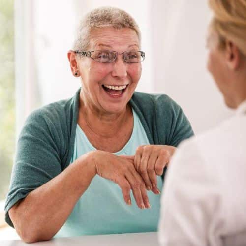 A woman smiling while talking to her Primary care doctor
