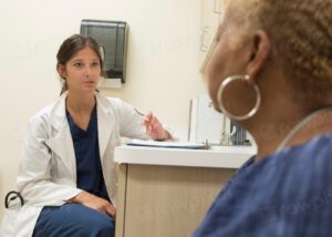 Doctor speaking with a healthy adult patient during a routine checkup in a clinic
