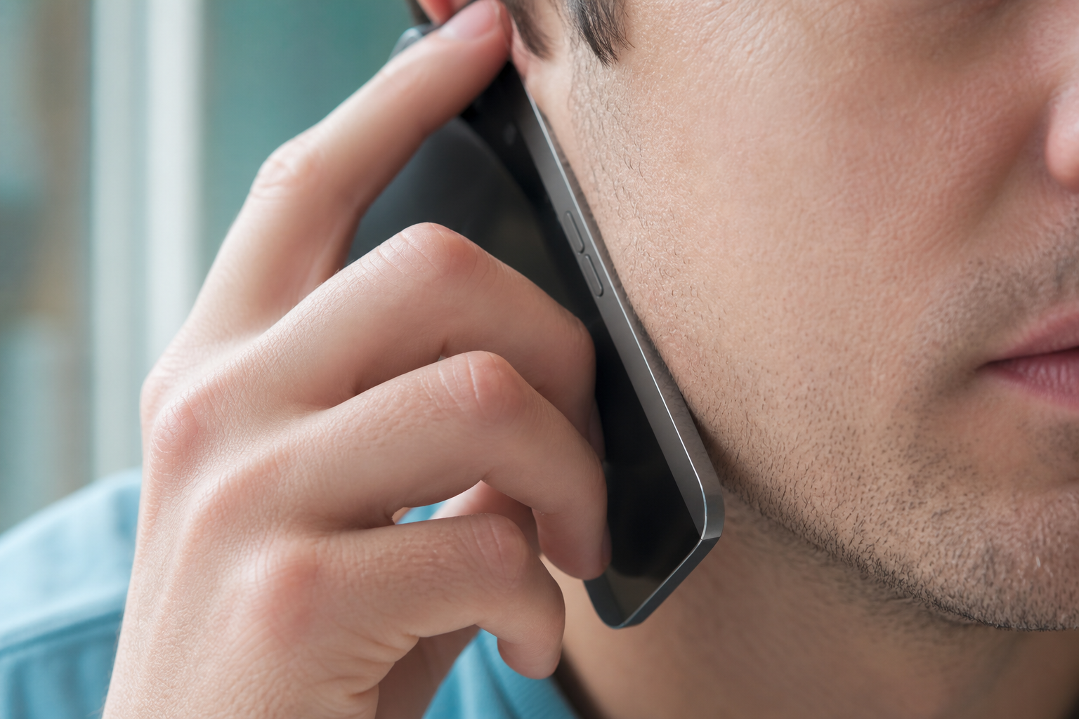 Person holding a smartphone near their face, illustrating phone contact with skin